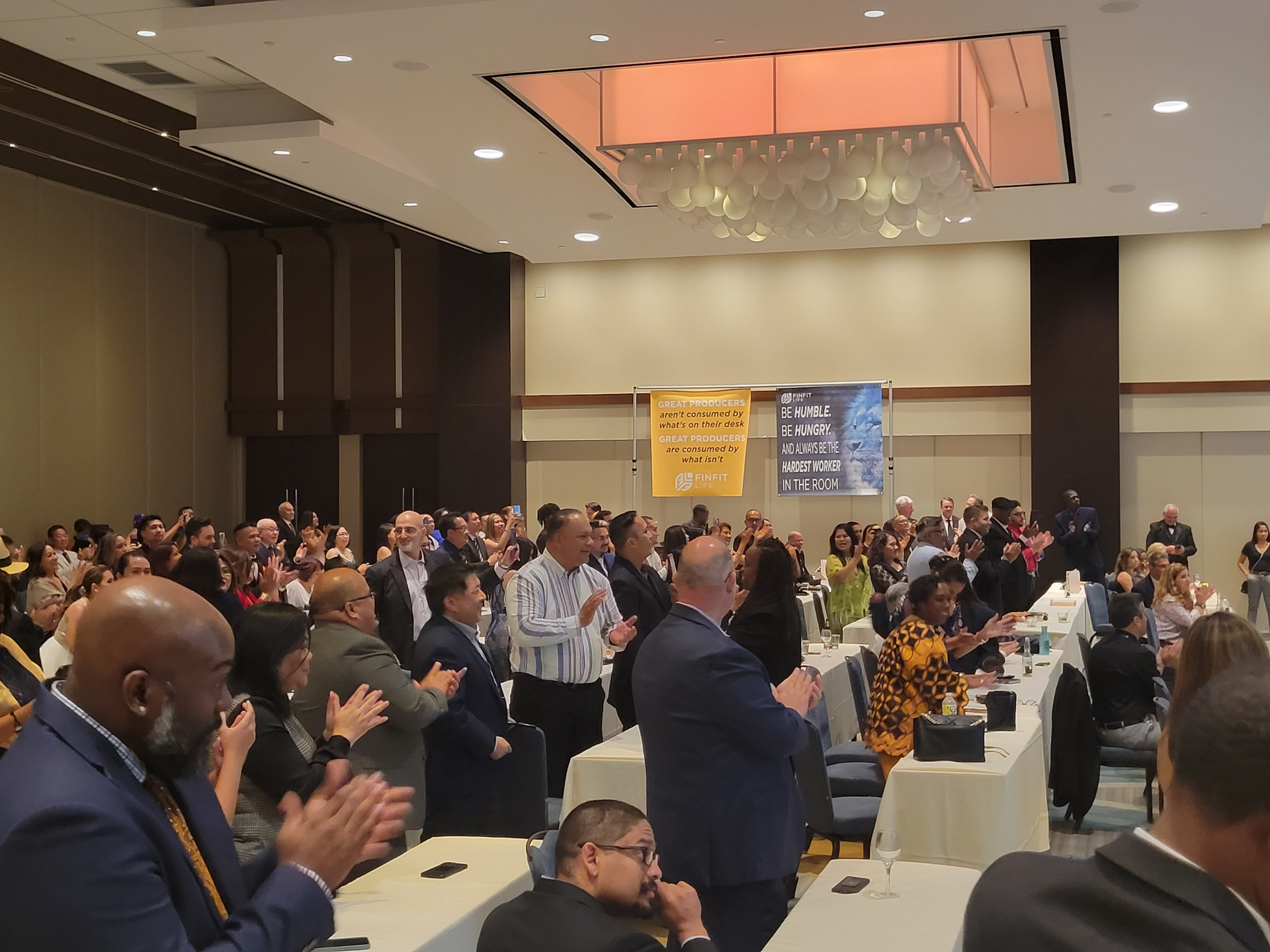 Team and attendees applauding at a leadership event